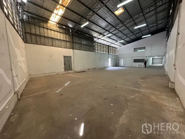 Warehouse for rent in Suan Luang, Bangkok - Spacious storage area with skylights, ventilation panels and loading access.