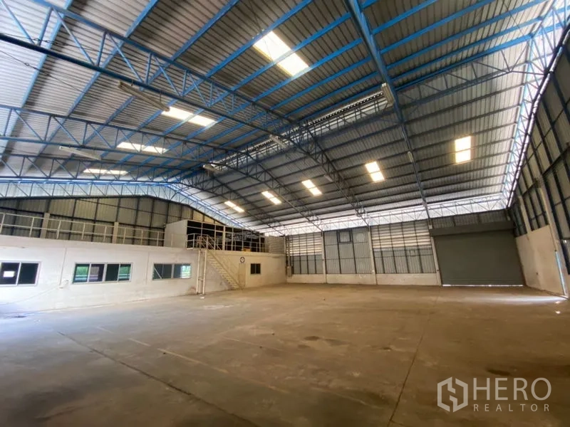 工厂 出租在Lat Lum Kaeo, Pathum Thani - 开阔混凝土地面，带夹层办公室与大型卷闸门。