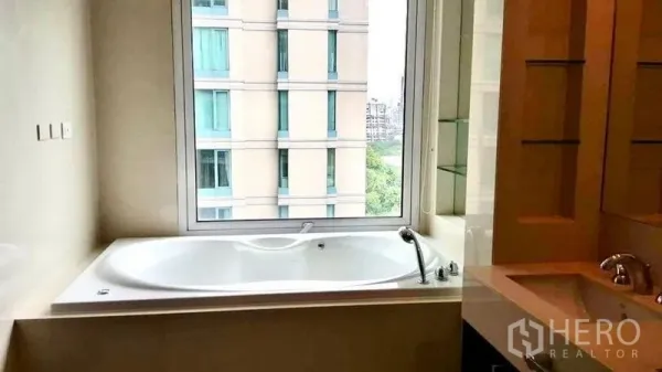 公寓 出租在Pathum Wan, Bangkok - 浴室设有观景大窗下的深浸泡浴缸，可眺望曼谷城景。