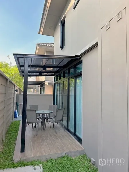 独立式住宅 出售 - 侧院露台，玻璃顶棚与户外餐桌，旁有草地