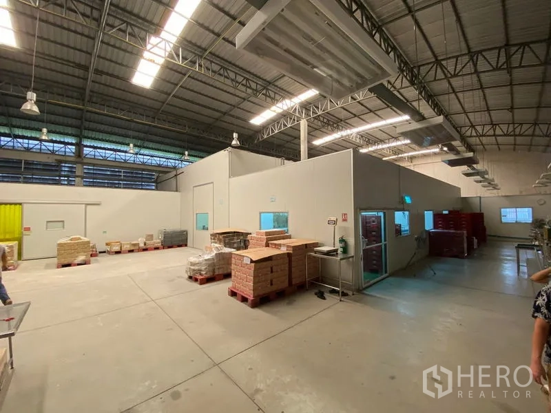 Warehouse for rent in Bueng Kum, Bangkok - Spacious food‑grade warehouse in Bueng Kum, Bangkok with high ceiling, insulated rooms and pallet staging under bright lighting.