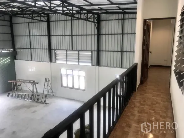 Warehouse for rent in Lam Luk Ka, Pathum Thani - Upper mezzanine walkway overlooking open warehouse floor with roller shutter and windows.