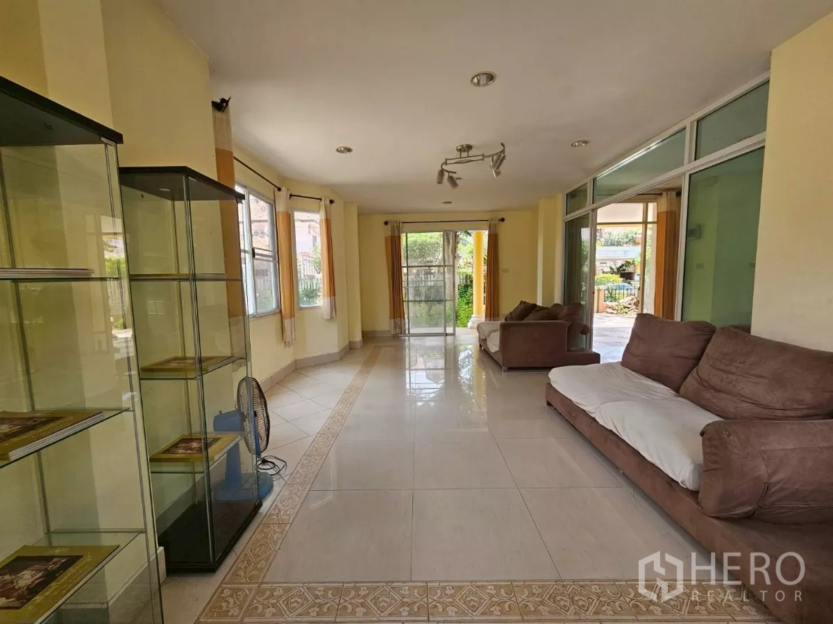 Detached House for rent or sale in Bang Lamung, Chon Buri - Long lounge connecting to the porch via sliding doors, with display shelves.