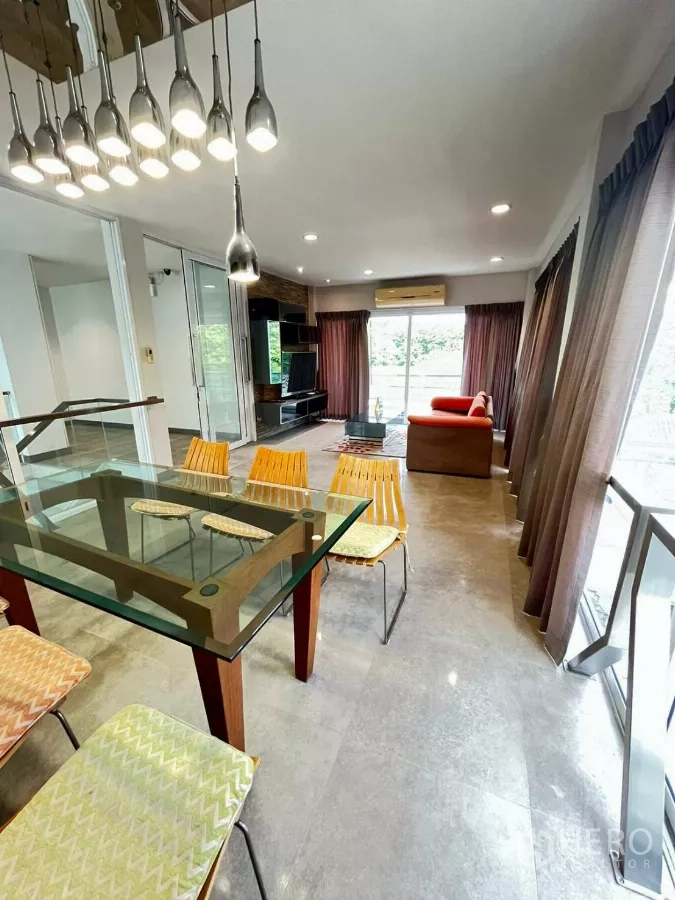 Home Office for rent in Khlong Toei, Bangkok - Dining space with glass-top table and pendant lights next to wide windows.