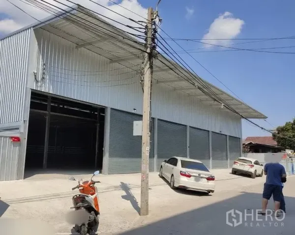 货栈 出租在Bang Kapi, Bangkok - 现代金属外墙仓库外观，车道宽敞并设多组卷闸装卸门。