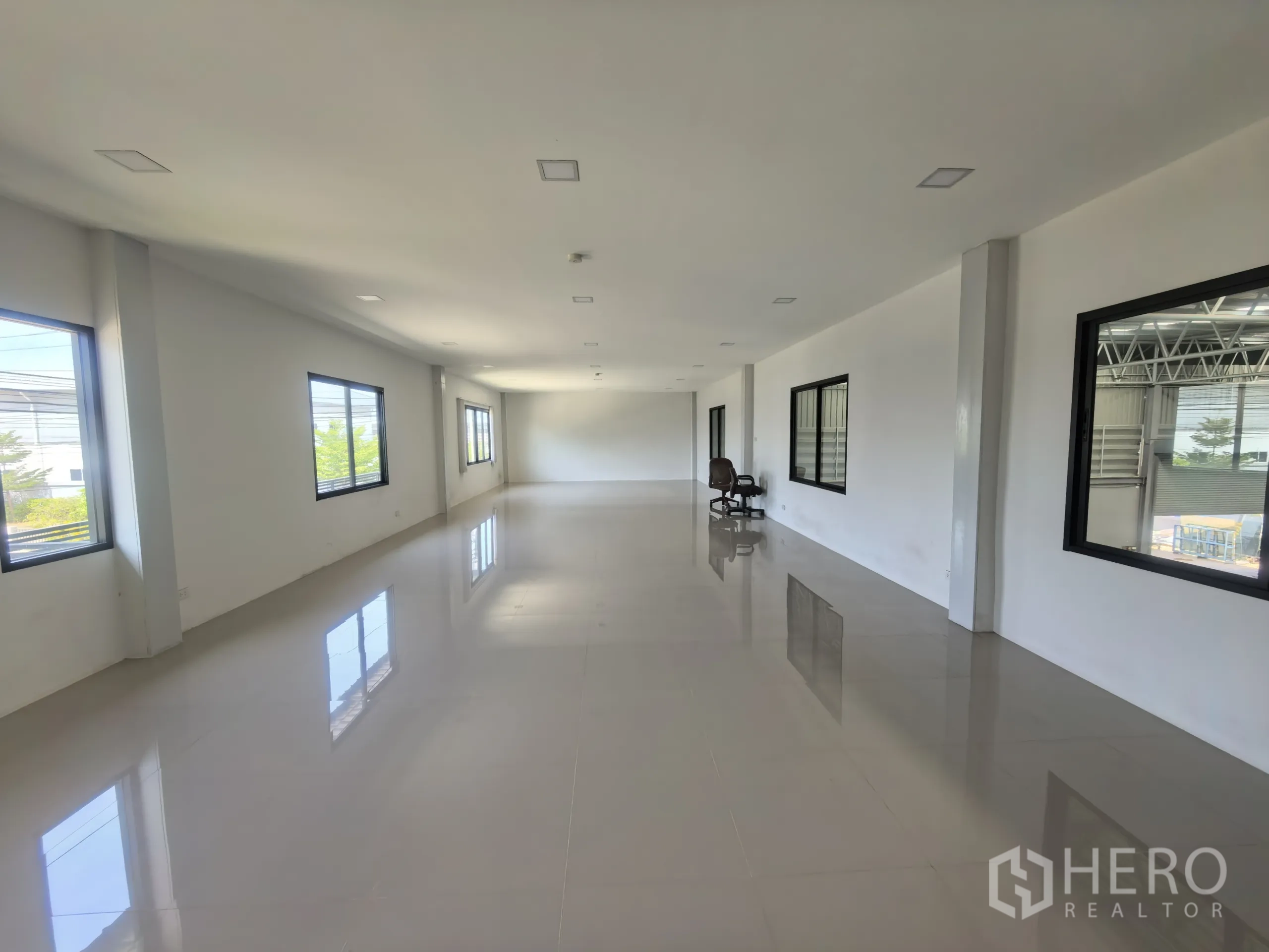 Factory for rent or sale in Khlong Toei, Bangkok - Long corridor‑style office space with polished tiles and natural light from multiple windows.