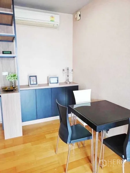 Condominium for sale in Khlong San, Bangkok - Bright dining area with open shelving and two-tone chairs.