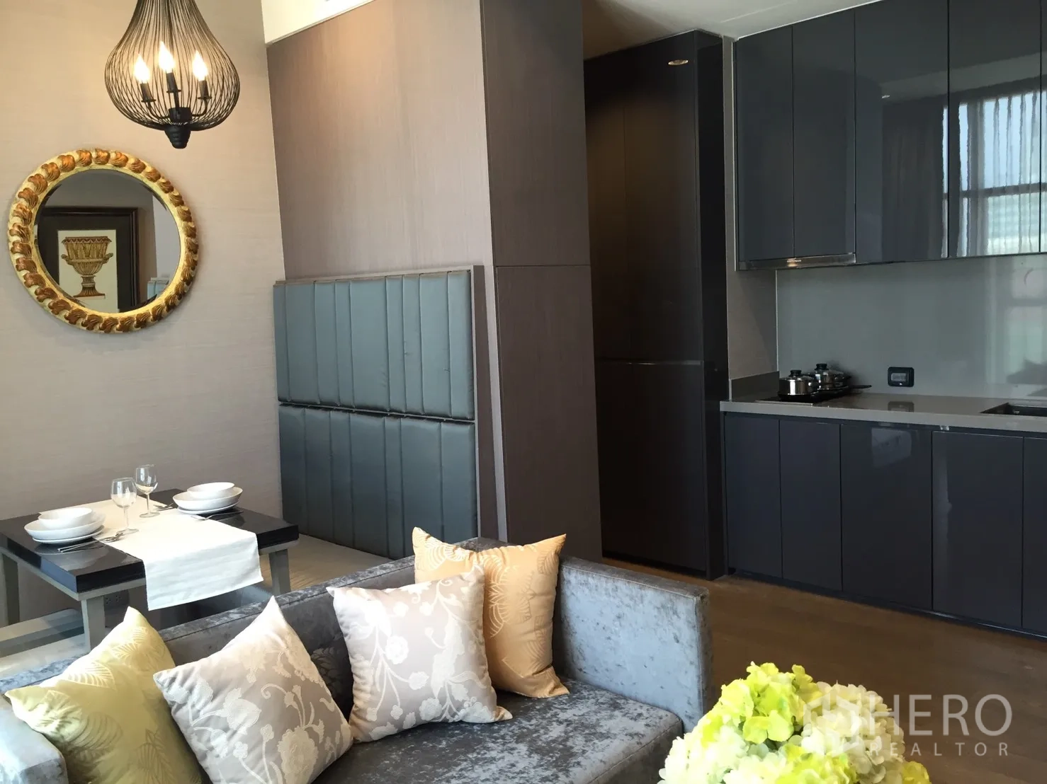 公寓 出租在Bang Rak, Bangkok - 开放式客厅，双人餐桌与高光柜面的一体化厨房。
