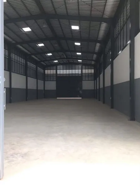 Warehouse for rent or sale in Nong Chok, Bangkok - Spacious warehouse interior with high arched steel roof, concrete floor and large roller shutter.