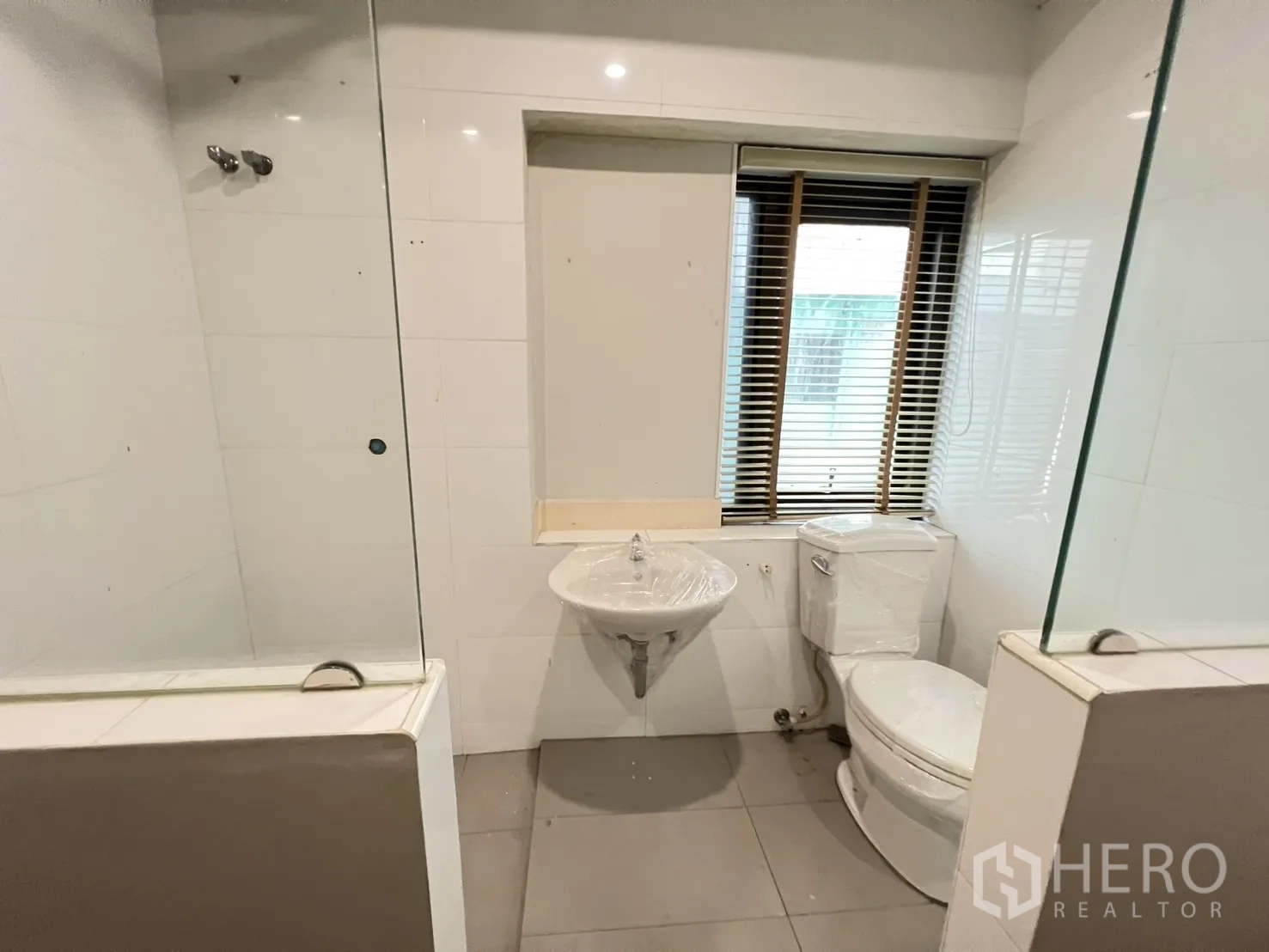 店屋 出租在Bang Rak, Bangkok - 带窗卫生间，设洗手盆、坐厕与玻璃淋浴隔断。