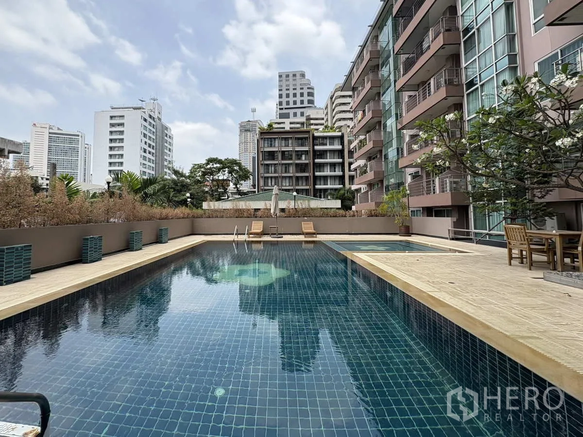 公寓 出租在Khlong Toei, Bangkok - 户外泳池，周围为低层楼栋与休憩座位。