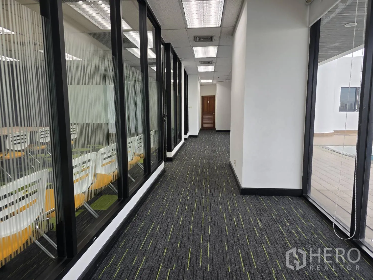Office Space for rent in Watthana, Bangkok - Corridor beside a meeting room and windows opening to the pool deck.