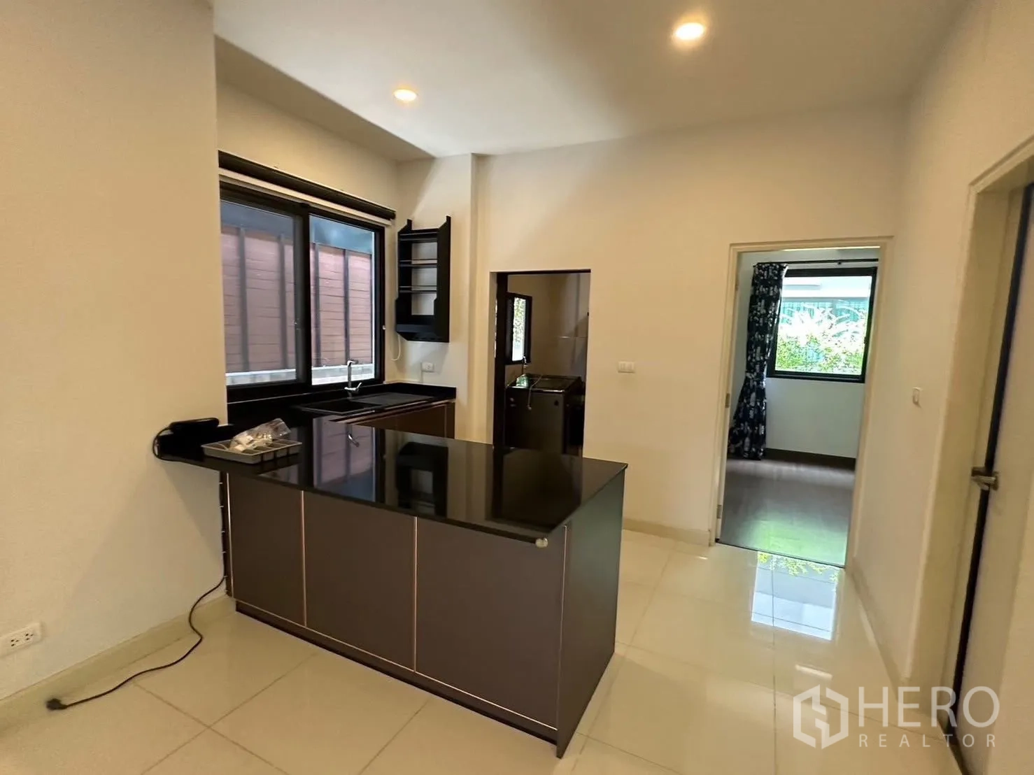 独栋房屋 for rent in Bang Phli, Samut Prakan - 可见厨房半岛台及连接的采光房间。