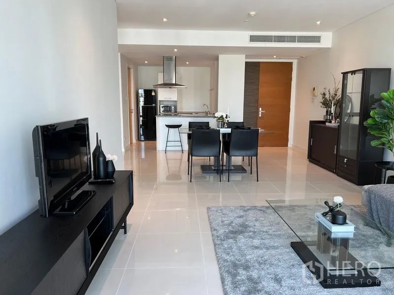 公寓 出租在Watthana, Bangkok - 宽敞起居空间，亮面地砖、电视柜、餐区及厨房中岛一体。