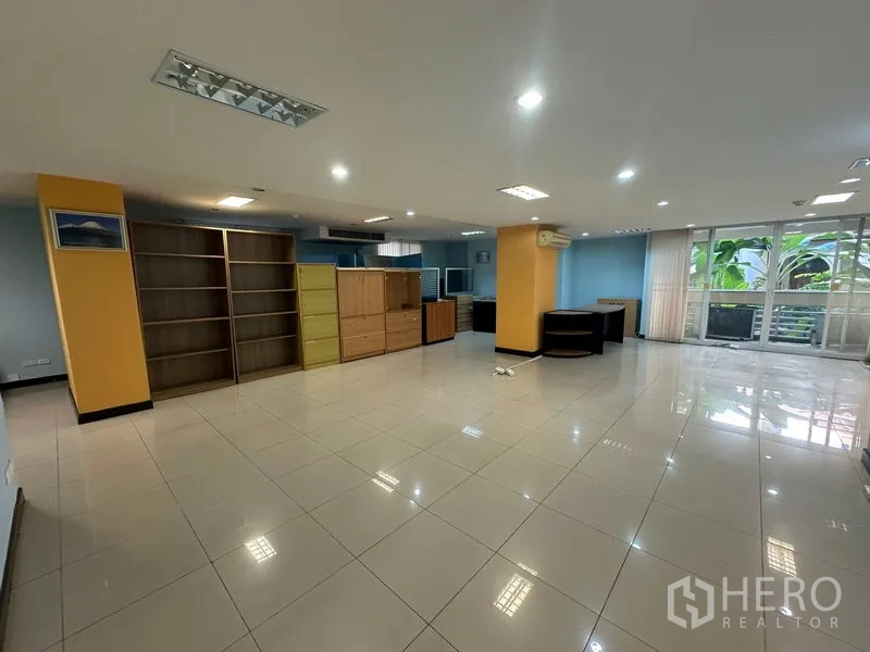 สำนักงาน ขาย - ออฟฟิศแบบเปิดมีชั้นเก็บเอกสาร โต๊ะทำงาน และประตูกระจกสไลด์สู่สวน