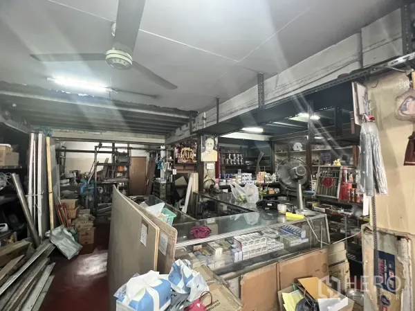 พื้นที่ขายปลีก ให้เช่าในWatthana, Bangkok - ภายในร้านพร้อมเคาน์เตอร์กระจก พัดลมเพดาน และชั้นเหล็กสำหรับสินค้า