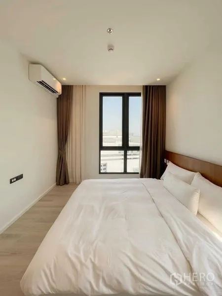 Condominium for rent or sale - Cozy bedroom with double bed, tall window, air conditioner and city outlook.