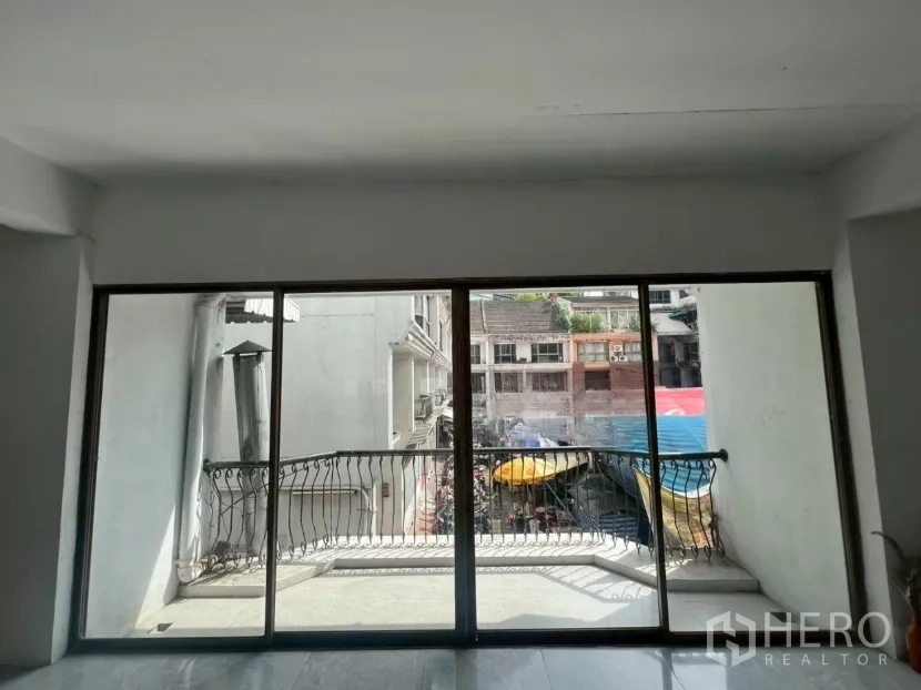 零售空间 出租在Pathum Wan, Bangkok - 二层房间，推拉落地门通向小阳台，俯瞰街市