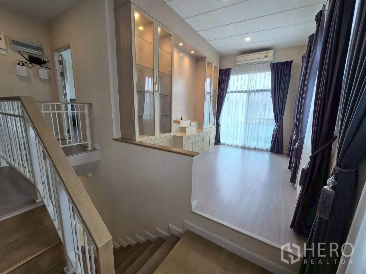 Detached House for rent or sale in Lat Krabang, Bangkok - Upstairs area with built-in cabinets, vanity, and balcony-style glass door.