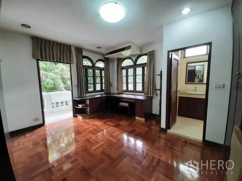 独立式住宅 出租在Watthana, Bangkok - 卧室带转角书桌、可通阳台并连通套卫的门。