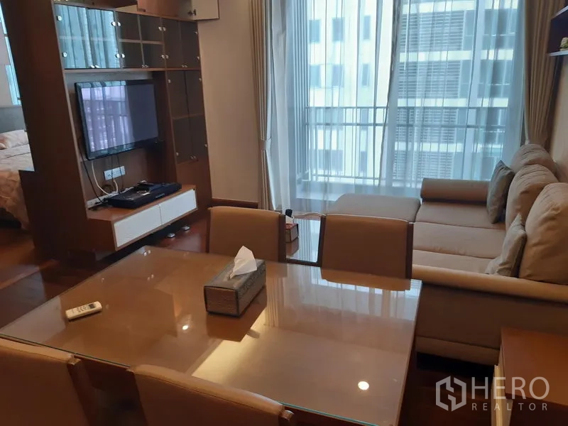 คอนโด ให้เช่าในWatthana, Bangkok - ส่วนรับประทานอาหารเชื่อมสู่ห้องนั่งเล่น ทีวีติดผนัง พร้อมประตูกระจกบานเลื่อนออกไประเบียง