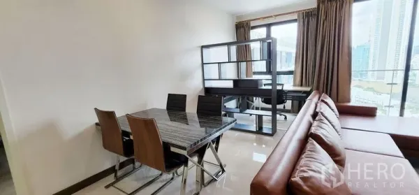 Condominium for rent - Dining area with a marble-top table and four chairs beside a work desk and shelving by the window.