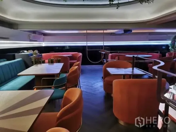 พื้นที่ขายปลีก ให้เช่า - พื้นที่นั่งชั้นบน เก้าอี้สีคอรัล โต๊ะสี่เหลี่ยม และไฟเส้น LED