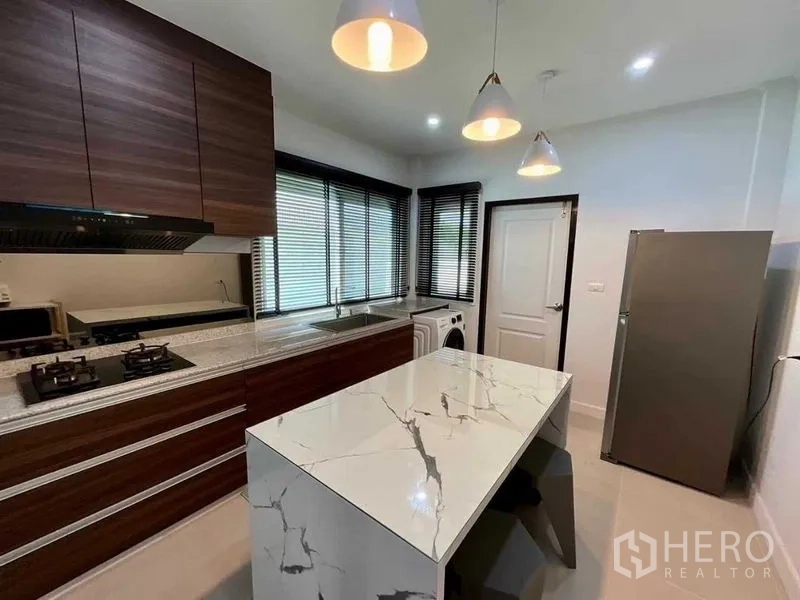 บ้าน ขายในBang Sao Thong, Samut Prakan - ครัวสมัยใหม่ มีไอส์แลนด์หินอ่อน เตาแก๊ส ตู้ไม้โทนเข้ม และหน้าต่างบานใหญ่