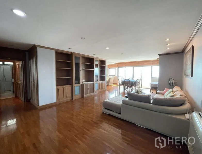 คอนโด ให้เช่า - ห้องนั่งเล่นคอนโดสาทรกว้าง พื้นไม้จริง ตู้บิลท์อิน โซฟามุม ชุดทานอาหาร และหน้าต่างบานใหญ่
