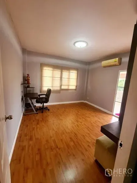 บ้าน ให้เช่าในSai Mai, Bangkok - ห้องกว้างปูพื้นไม้ มีโต๊ะทำงาน ม่านบังแดด และเครื่องปรับอากาศติดผนัง