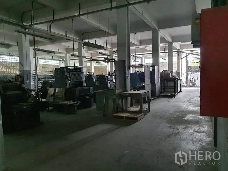 工厂 出售在Bang Khun Thian, Bangkok - 沿通道布置的印刷机与工作台，通向卷闸门