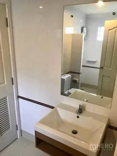 Detached House for rent in Bang Phli, Samut Prakan - Tiled bathroom with square basin, large mirror and a view toward the toilet and shower area.