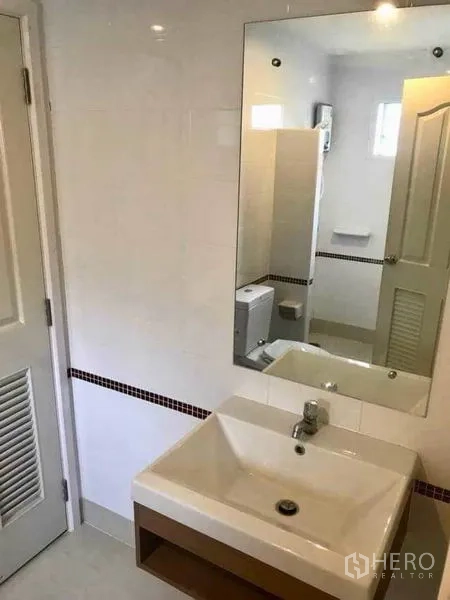 Detached House for rent in Bang Phli, Samut Prakan - Tiled bathroom with square basin, large mirror and a view toward the toilet and shower area.