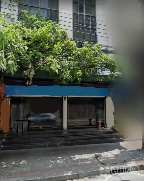 อาคารพาณิชย์ ให้เช่าในWatthana, Bangkok - ด้านหน้าอาคารพาณิชย์ติดถนน หน้ากระจกกว้าง มีขั้นบันไดและต้นไม้ร่มเงาในเขตวัฒนา