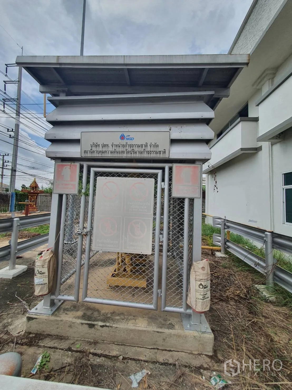 仓库 for rent in Phra Nakhon Si Ayutthaya, Phra Nakhon Si Ayutthaya - 建筑旁加固的公用设施柜，设有安全标识与围网。