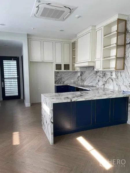 Detached House for sale in Saphan Sung, Bangkok - Modern kitchen with marble countertops, navy cabinetry, and built‑in storage.