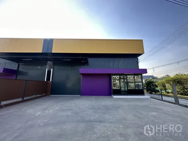 คลังสินค้า ให้เช่าในLam Luk Ka, Pathum Thani - ลานคอนกรีตกว้างหน้าตัวโกดังสีเทา-เหลือง เหมาะสำหรับการโหลดสินค้า