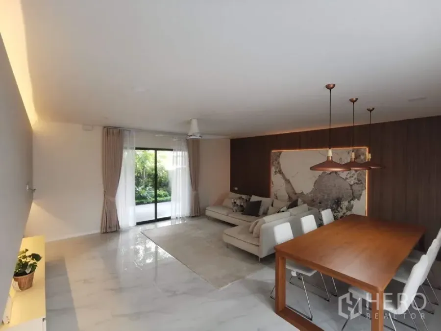 Townhouse for rent in Bang Phli, Samut Prakan - Spacious living-dining space with marble-look floor and sliding doors opening to greenery.