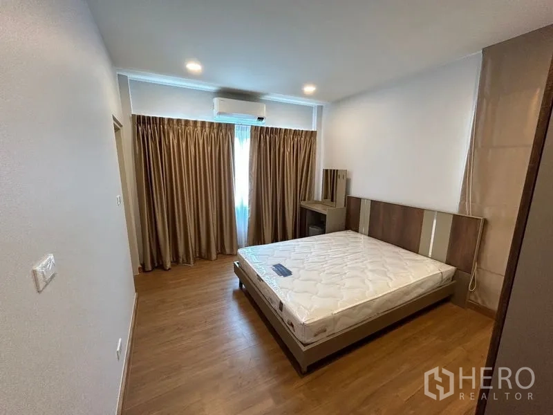 Detached House for rent in Bang Phli, Samut Prakan - Bedroom with bed, air conditioning, curtains and door to en-suite bath.