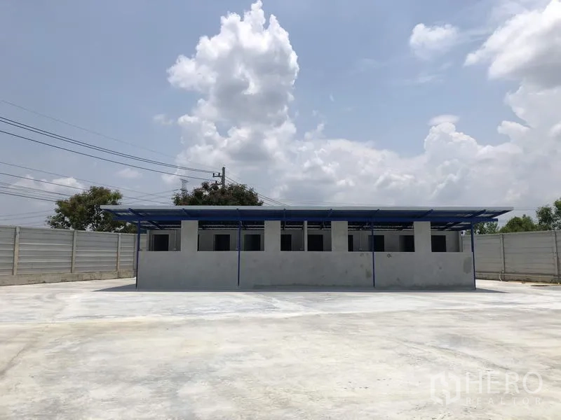 Factory for rent or sale in Lat Lum Kaeo, Pathum Thani - Separate utility block with roof canopy situated on a large paved yard.
