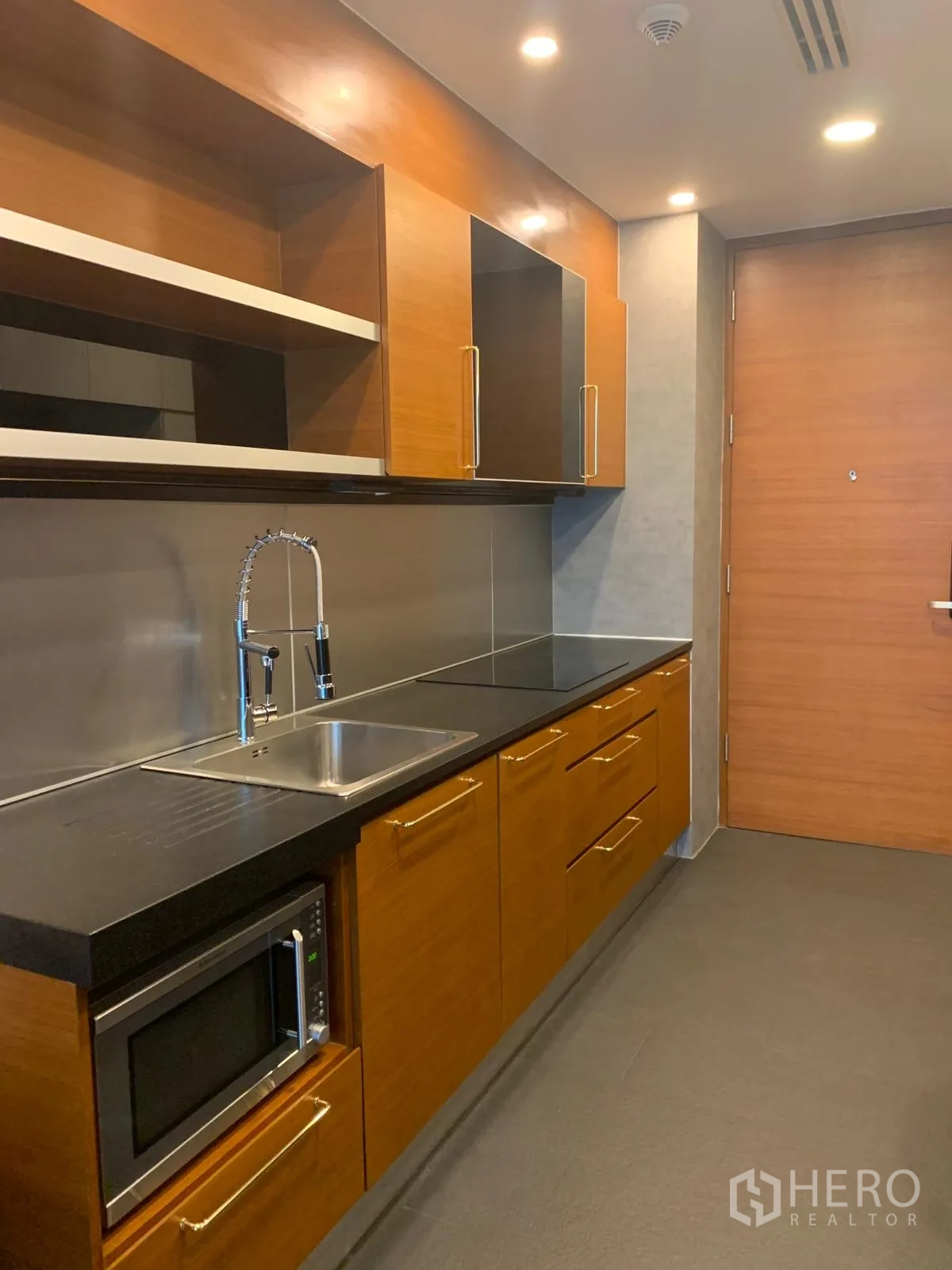 公寓 出售在Khlong Toei, Bangkok - 厨房近景：橱柜、水槽、炉灶与嵌入式微波炉。