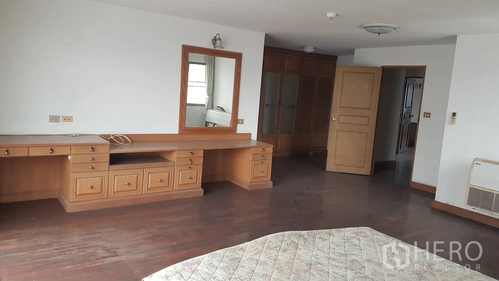 คอนโด ให้เช่าในKhlong Toei, Bangkok - มุมแต่งตัวห้องนอนใหญ่ โต๊ะบิลต์อินยาว กระจก และตู้เสื้อผ้า พื้นไม้