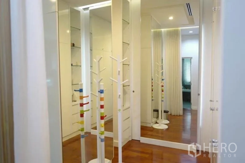 Detached House for sale in Pak Kret, Nonthaburi - Upstairs corridor with mirrored built-in wardrobes and warm wood flooring.