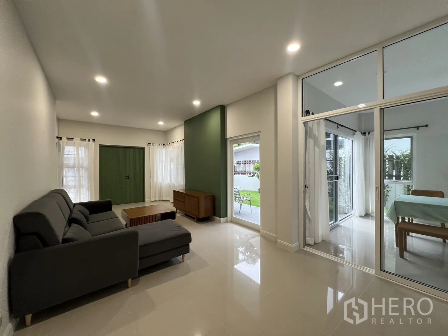 Detached House for rent in Saphan Sung, Bangkok - Lounge opening to a glass-walled dining room with garden outlook.