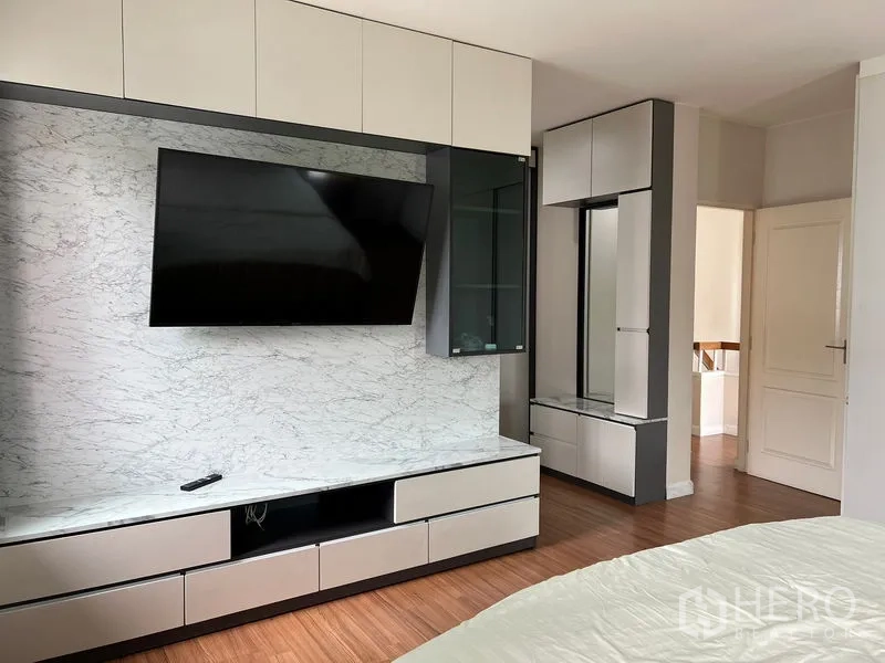 Detached House for rent in Bang Kapi, Bangkok - Master bedroom media wall with marble-look panel, mounted TV, and custom storage.