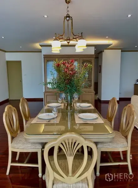 Condominium for rent or sale in Watthana, Bangkok - Formal dining table for six under pendant lighting beside a built-in display cabinet.