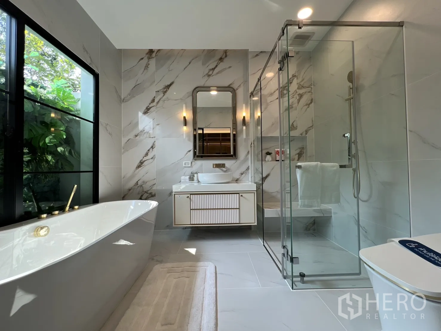 Detached House for rent in Saphan Sung, Bangkok - Luxury bathroom with freestanding tub, glass shower and marble tiles.