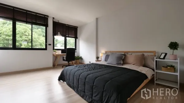 ทาวน์เฮาส์ ให้เช่าในHuai Khwang, Bangkok - ห้องนอนกว้างพร้อมโต๊ะทำงาน หน้าต่างบานใหญ่ พื้นไม้ และวิวต้นไม้