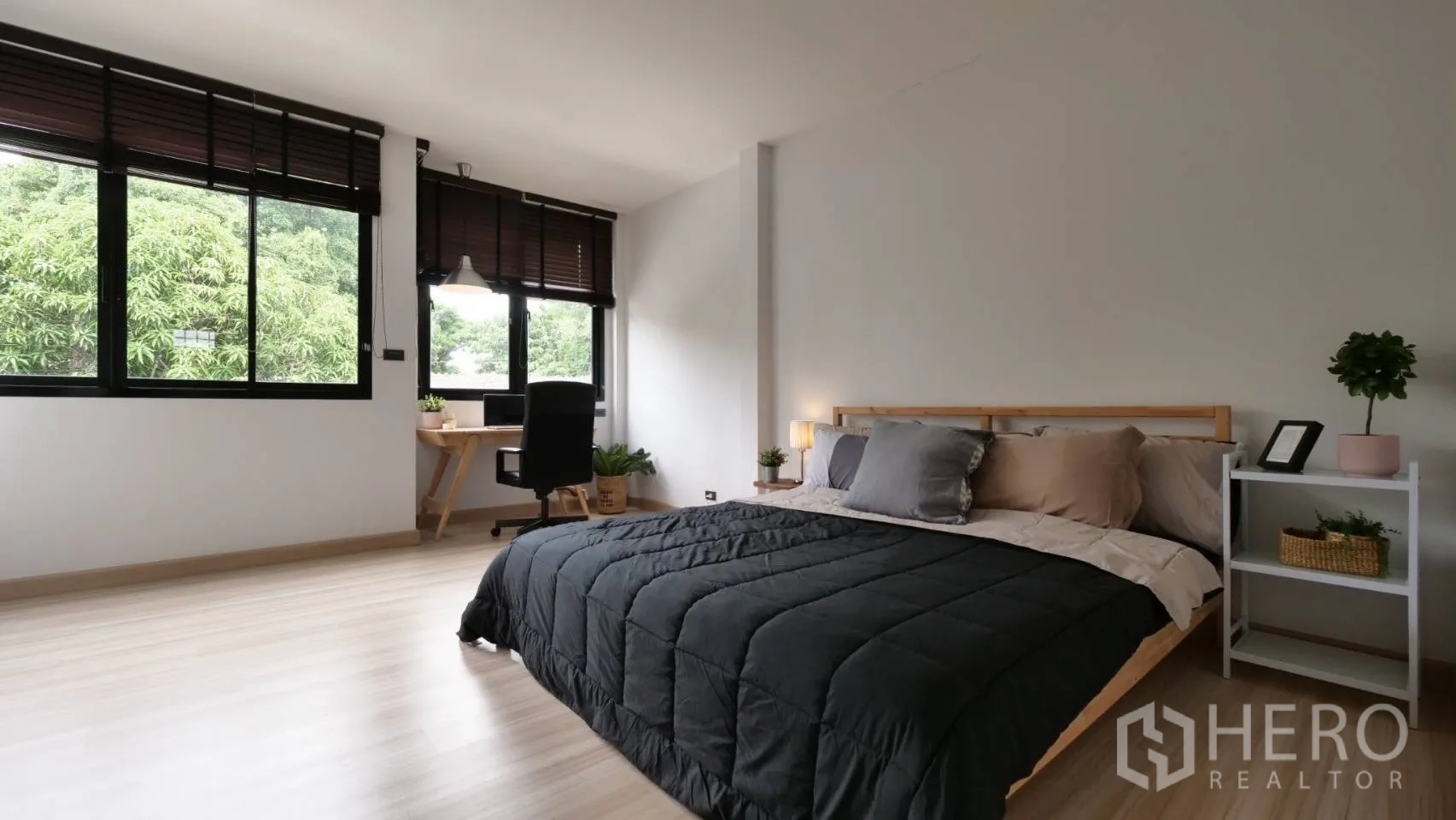 ทาวน์เฮาส์ ให้เช่าในHuai Khwang, Bangkok - ห้องนอนกว้างพร้อมโต๊ะทำงาน หน้าต่างบานใหญ่ พื้นไม้ และวิวต้นไม้