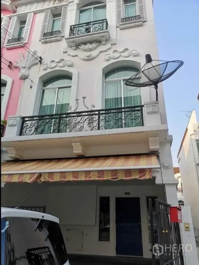 Detached House for rent in Wang Thonglang, Bangkok - European-style three-storey facade with wrought-iron balconies and striped awning.
